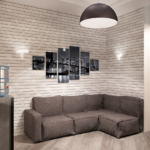 Визуализация кухни- гостиной 16 кв.м в светлых тонах с акцентами, серый диван, картина, декор, кирпич, подвесная люстра, бежевая пвх плитка