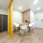 Интерьер коридора 25 кв.м офиса, барная стойка, белые барные стулья, пвх плитка, декоративная деревянная перегородка